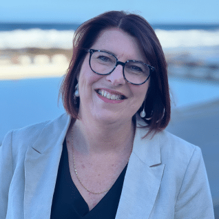 A smiling woman wearing glasses