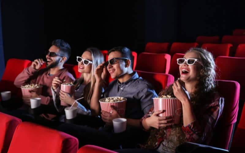 Group of friends enjoying a movie with popcorn