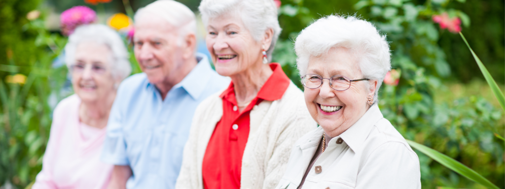 Three smiling ladies and a gentleman sitting in a row